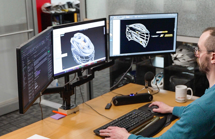 Person looking at Z HELMET designs on three monitors.